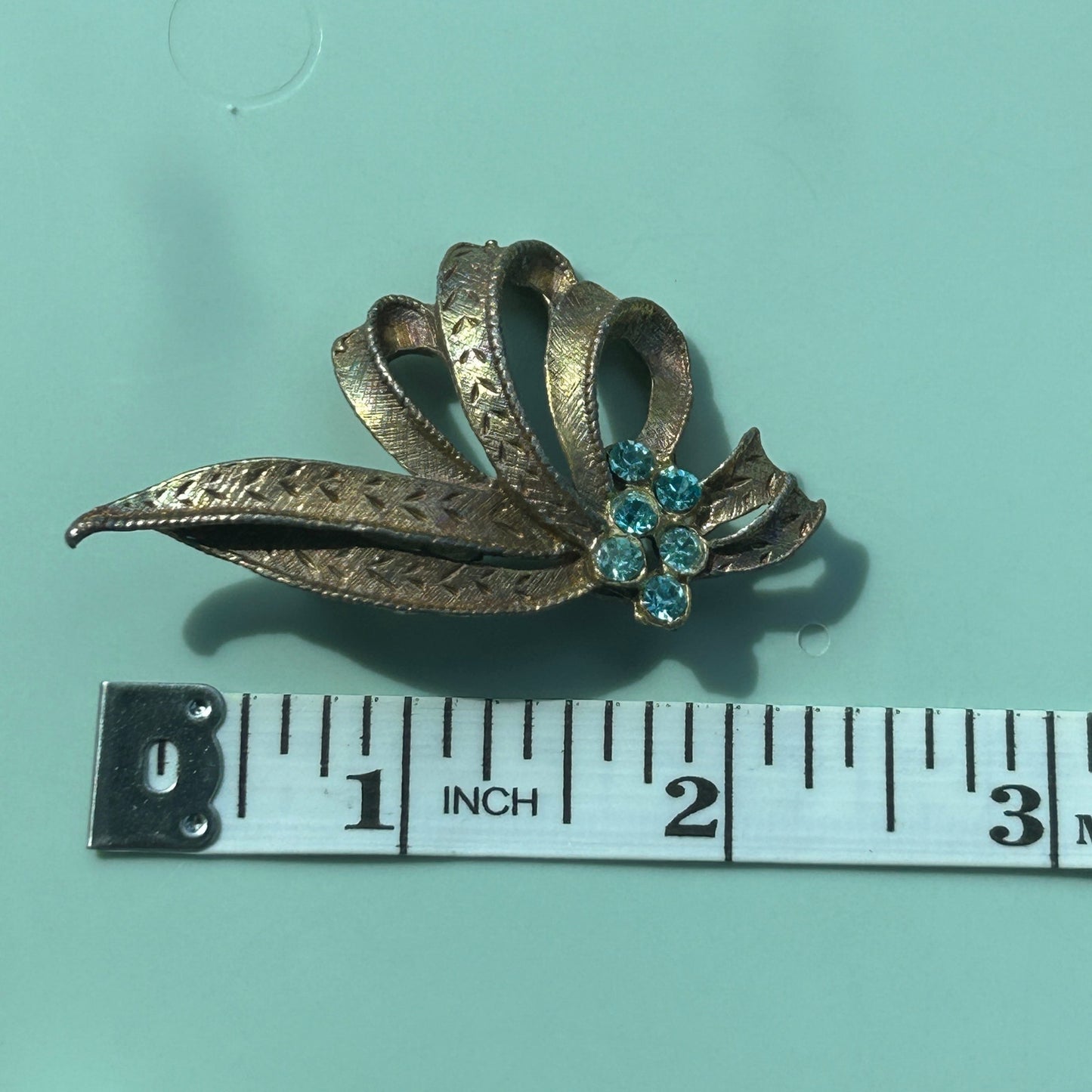 Vintage Gold-Tone Textured Ribbon Bow Brooch with Light Blue Rhinestone Accents